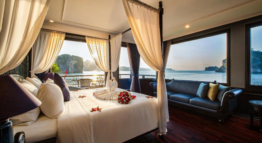 a hotel room with a bed, table, chairs and a window, Rosy Cruises in Hạ Long