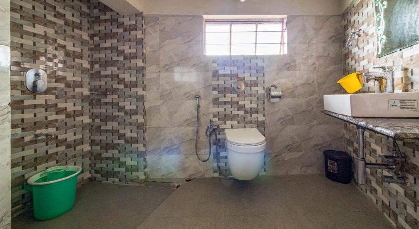 a bathroom with a toilet a sink and a tub, 7 Sisters Falls View Inn Hotel in Cherrapunji