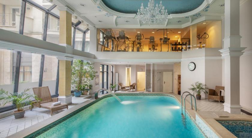 a large swimming pool in the middle of a room, Queen's Court Hotel & Residence in Budapest