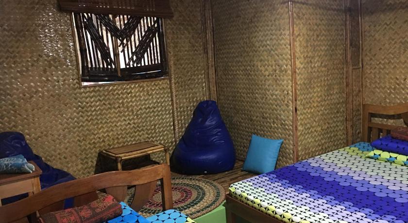 a bedroom with a bed, a desk and a painting on the wall, Bamboo Nest in Palawan