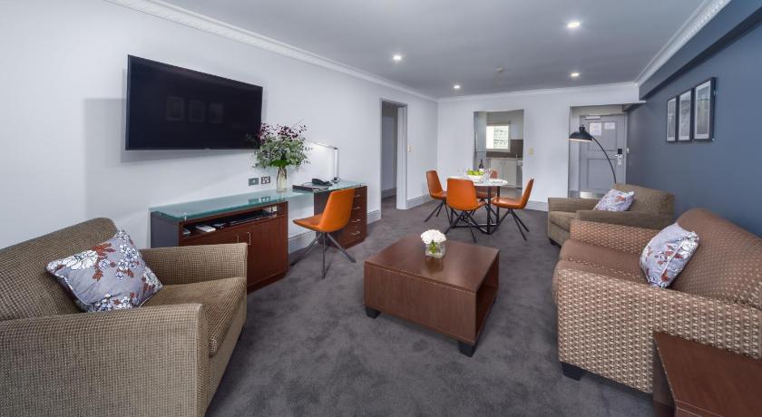 a living room filled with furniture and a couch, Hyde Park Inn Hotel in Sydney