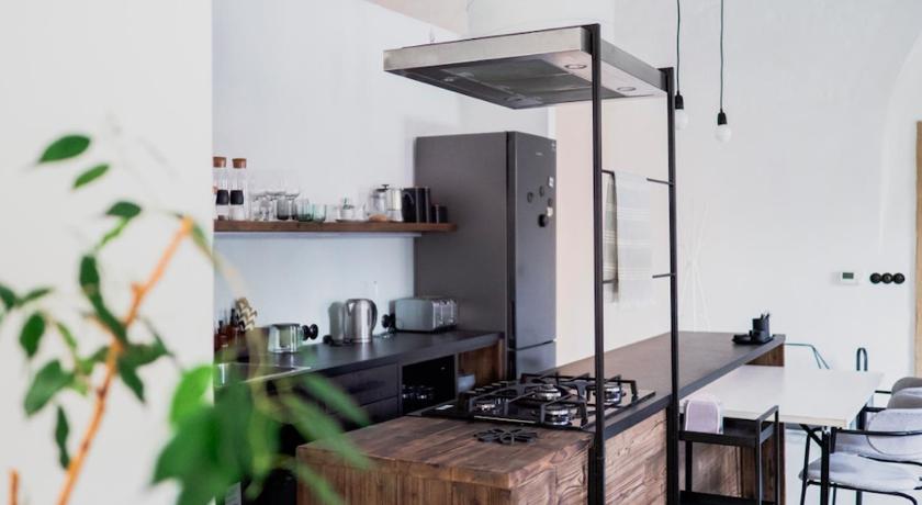 a kitchen with a stove top oven and a refrigerator, Long Story Short Hostel & Cafe in Olomouc