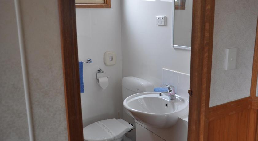 a bathroom with a toilet, sink and mirror, Western Ki Caravan Park Cabins in Kangaroo Island