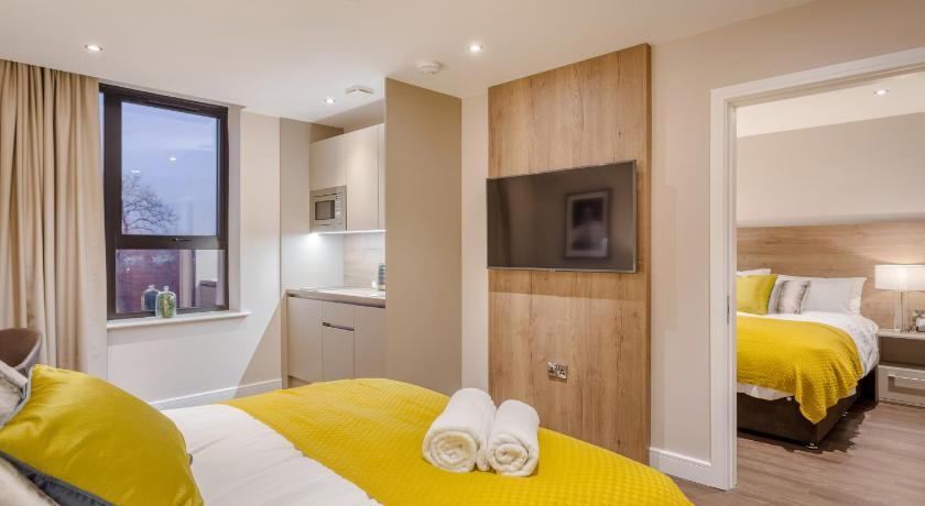 a hotel room with two beds and a television, Dwell City Living in Nottingham