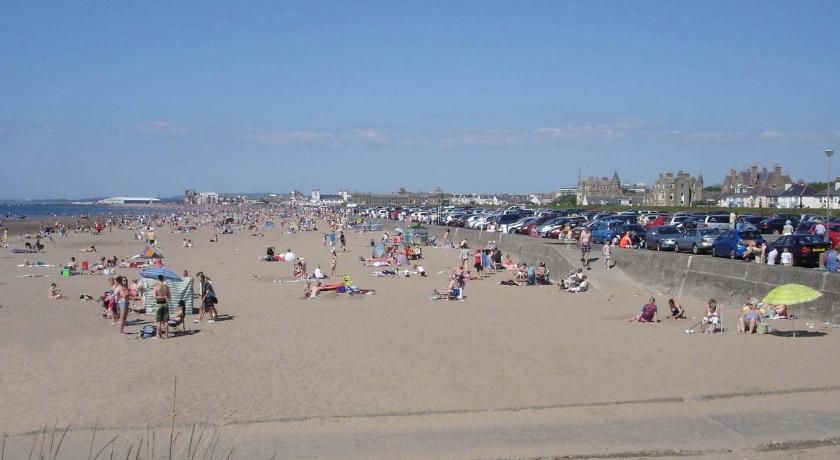 a beach filled with lots of people on a sunny day, Barns Serviced Accommodation in Ayr