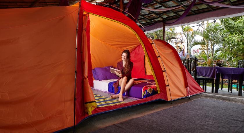 a woman is sitting in a tent in a building, Hiker's Camp at Toya Devasya in Bali