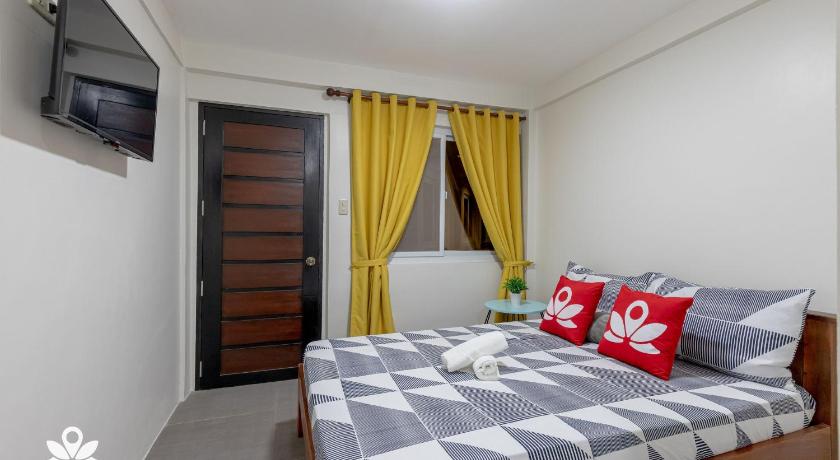 a bedroom with a bed and a dresser, Happy Grey Hotel Vigan in Ilocos Sur