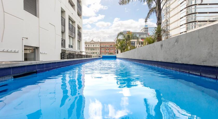 a pool of water with a blue sky, Auckland Harbour Suites in Auckland