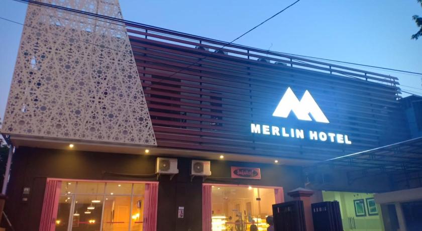 a neon sign on the side of a building, Merlin Hotel in Flores