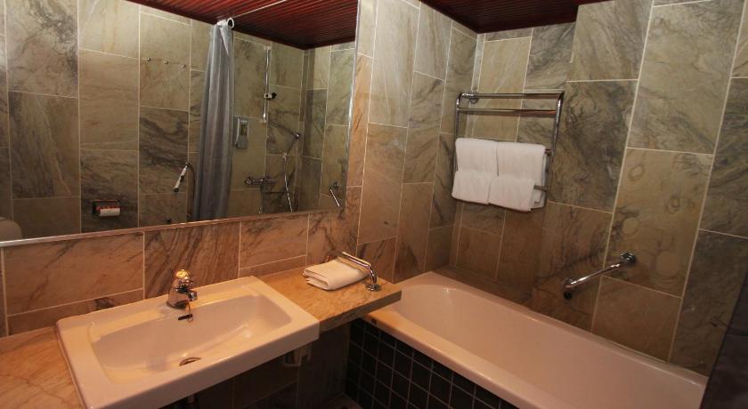 a bathroom with a tub, sink and mirror, Hotel Merihovi in Kemi