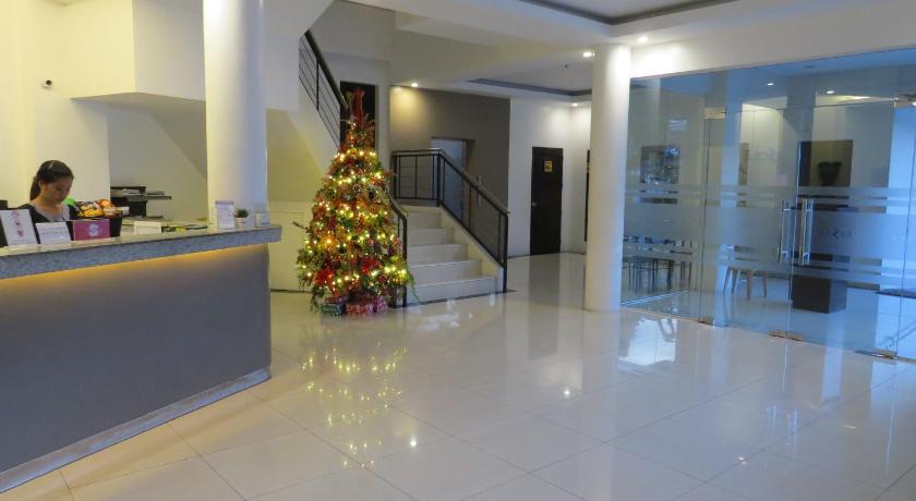 a room with a christmas tree in the middle of it, Fiesole Residence Inn in Dumaguete