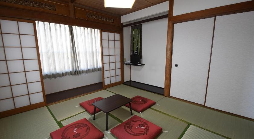 a living room filled with furniture next to a window, Onsen yado Hamayu Nagi in Beppu