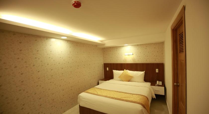 a bedroom with a bed and a dresser, Kim Hoa Hotel in Dalat