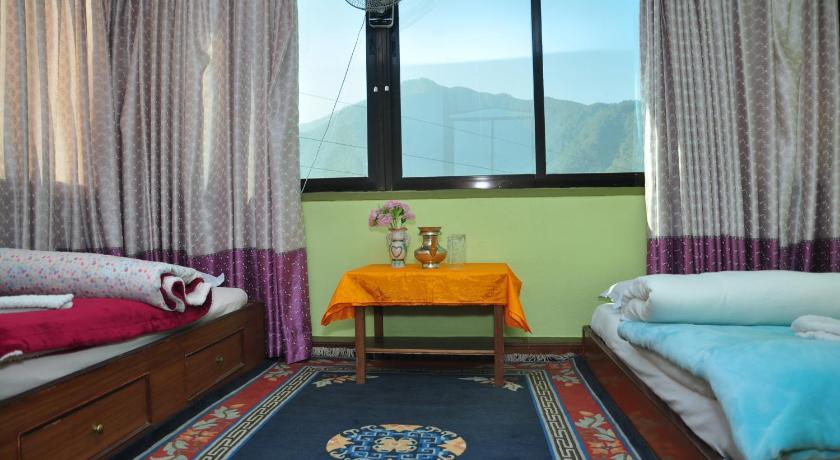 a room with a bed, chair, table and window, Nagarjun Home Stay in Kathmandu