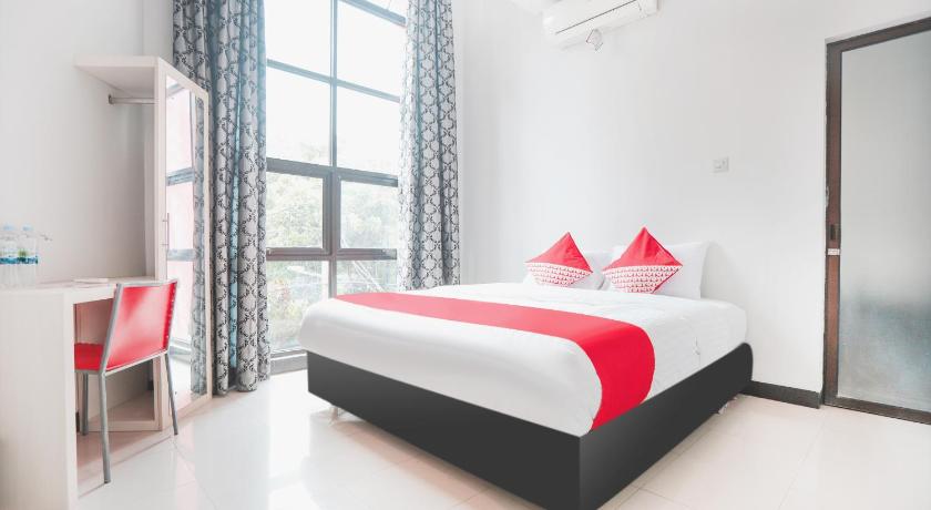 a bedroom with a large bed and a large window, Super OYO 148 Cempaka Place Homestay in Jakarta