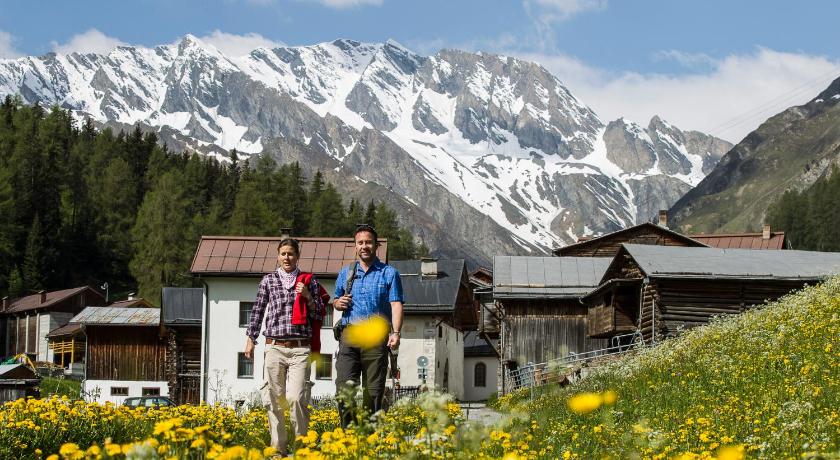 a man and woman standing in front of a mountain range, Samnaunerhof Vital-Hotel in Samnaun