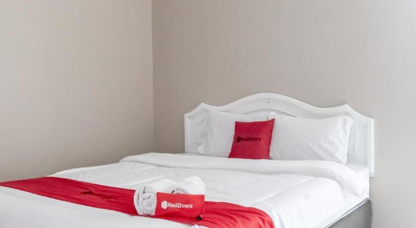 a neatly made bed in a hotel room, RedDoorz Plus near Tambun Station in Bekasi