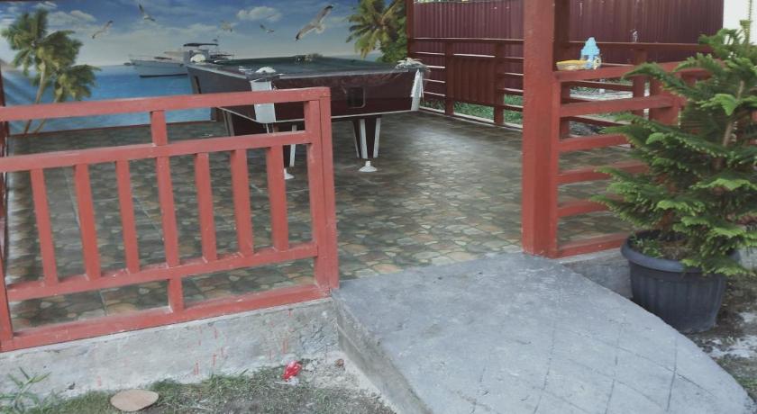 a wooden bench sitting in front of a red fire hydrant, Pondok Oma in Matanurung