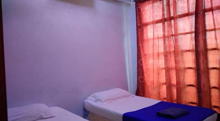 a bed room with two beds and a window, Penginapan Villa D Doa Maju in Kuala Terengganu