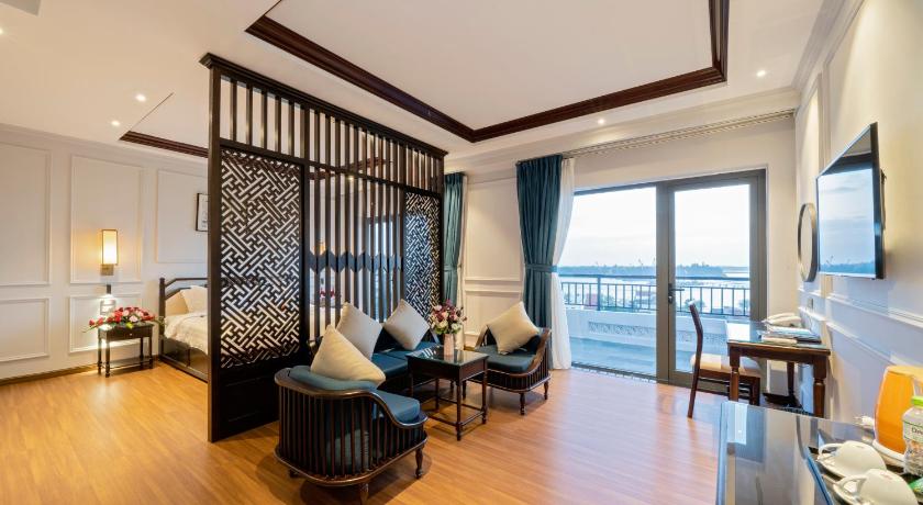 a living room filled with furniture and a large window, Eco Lux Riverside Hotel & Spa in Hoi An