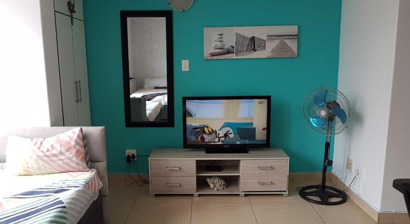 a room with a flat screen tv and a computer monitor, Tenbury Apartments in Durban