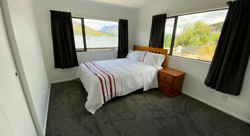 a bedroom with a bed, chair and a window, Frankton Gem in Queenstown
