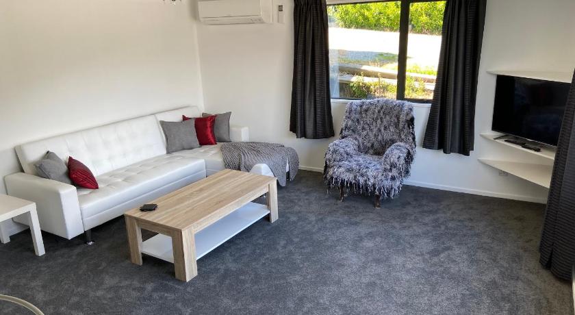 a living room filled with furniture and a tv, Frankton Gem in Queenstown