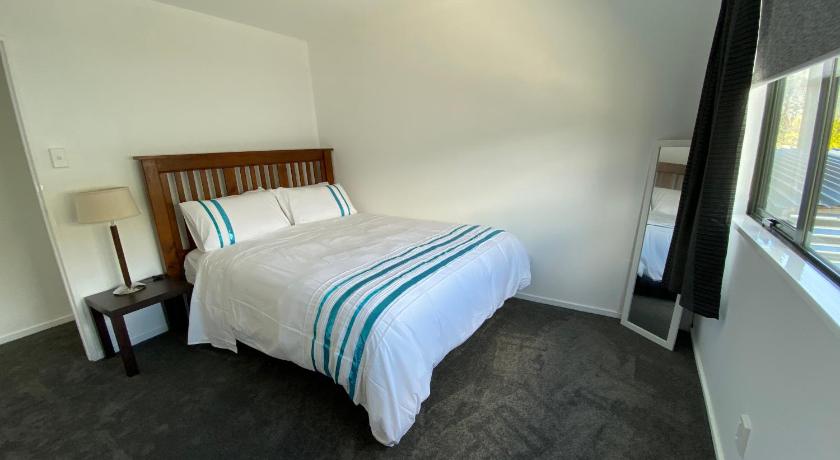 a bedroom with a bed and a dresser, Frankton Gem in Queenstown