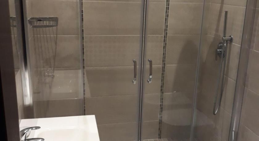 a white toilet sitting next to a shower in a bathroom, Hotel Villa Degli Angeli in Castel Gandolfo