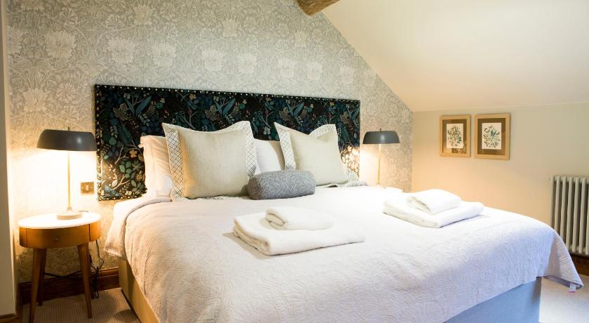 a bed with a white comforter and pillows on it, The Legh Arms Prestbury in Prestbury