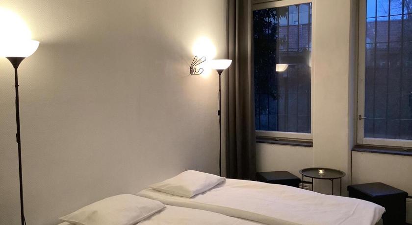 a bedroom with a bed and a lamp, Acco Hostel in Stockholm