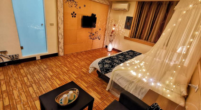 a bedroom with a bed and a television, Yilan Golf B&B in Yilan