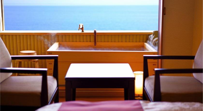 a dining room table and chairs in front of the ocean, Tenku Yubo Seikaiso in Beppu