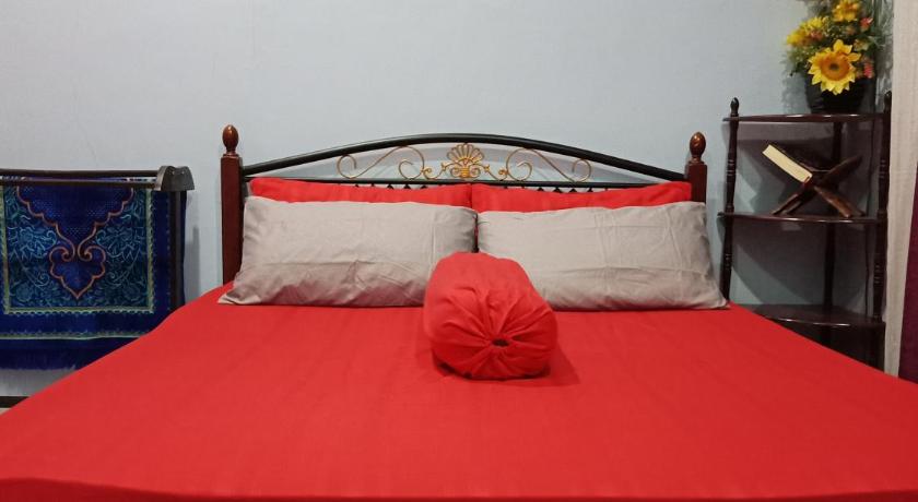 a bed with a red and white bedspread on top of it, Homestay Seri Nipah Perlis in Kangar
