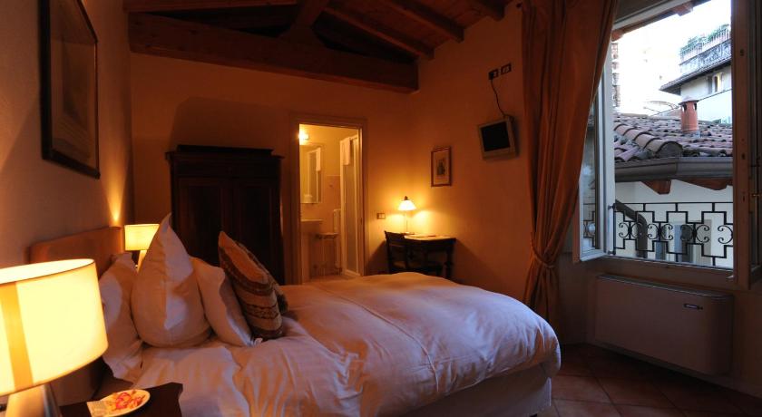 a bedroom with a bed and a window, Albergo Orologio in Brescia