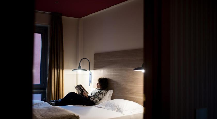 a person laying on a bed in a room, Hotel Torino in Parma