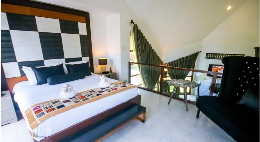 a bedroom with a large bed and a large window, Segara Villas in Subic (Zambales)