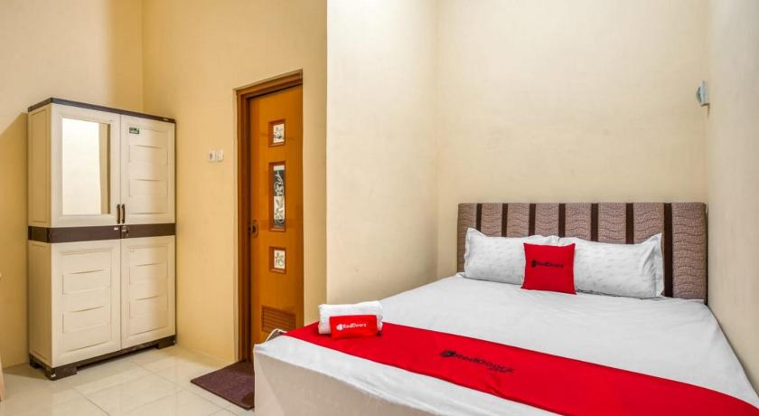 a bedroom with a bed and a dresser, RedDoorz Syariah near Kebon Rojo Park Blitar in Blitar
