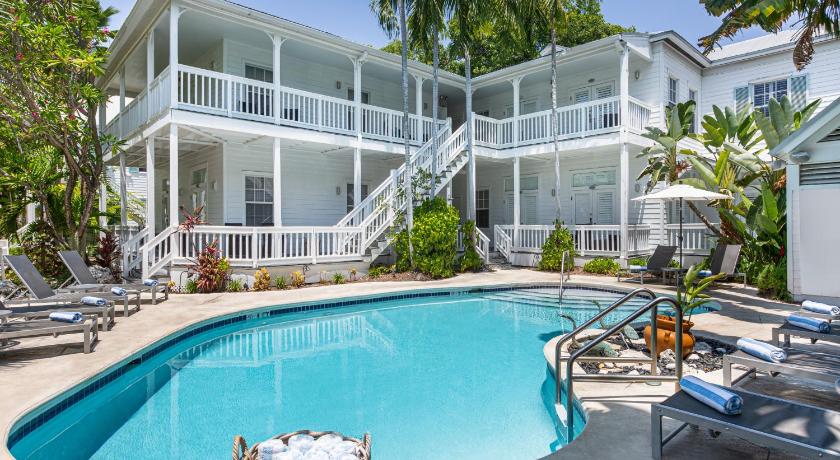 a large white swimming pool sitting in front of a house, The Paradise Inn - Adults Only in Key West (FL)