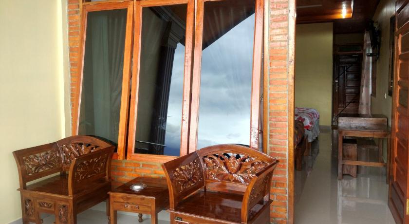 a room with two chairs and a wooden table, Gokhon Guest House in Samosir