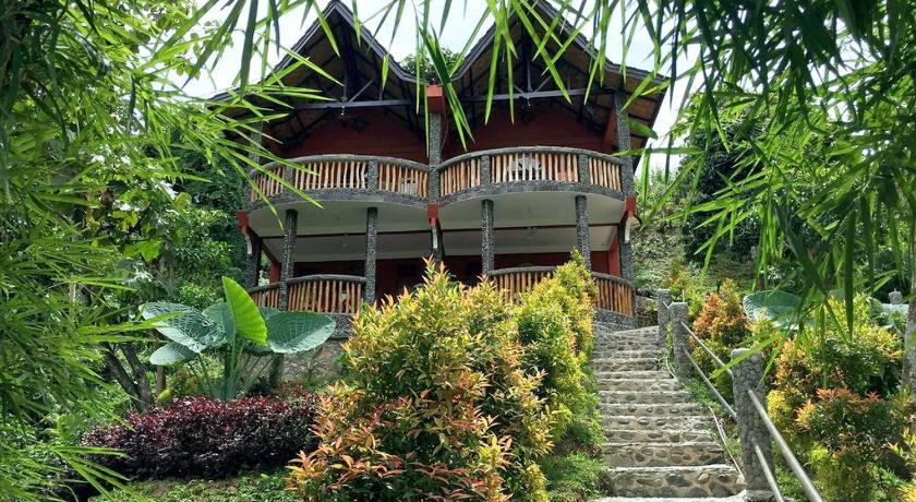 a staircase leading up to a balcony overlooking a forest, Hotel Orangutan in Bukit Lawang