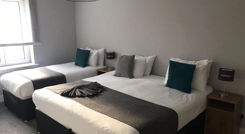 a hotel room with two beds and a lamp, Edinburgh Playhouse Apartments in Edinburgh