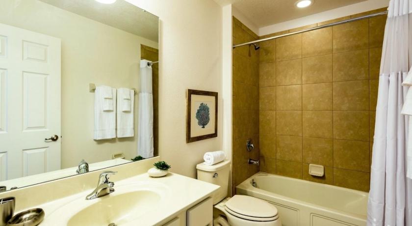 a bathroom with a toilet, sink, mirror and bathtub, Golf View Vacation Homes in Orlando (FL)