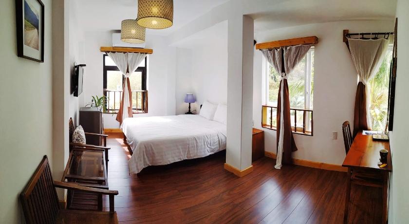 a bedroom with a bed, chair and a window, Hotel De Condor in Côn Đảo Islands