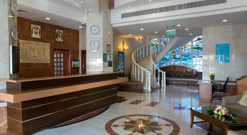 a living room filled with furniture and a large clock, Ramada by Wyndham Beach Hotel Ajman in Ajman