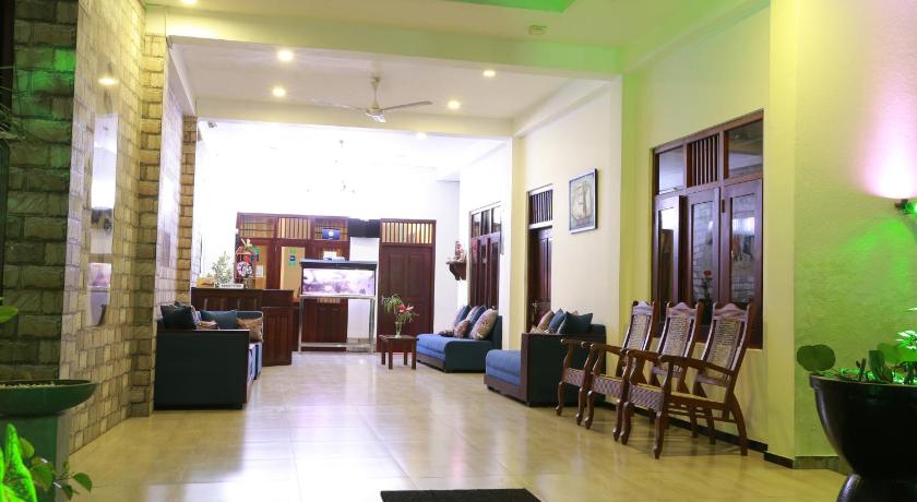 a living room filled with furniture and a large window, Hotel Bay Watch in Unawatuna