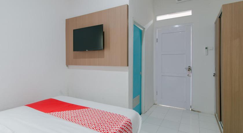 a bedroom with a white bed and white walls, OYO 2228 Arwinda Costel Syariah in Puncak