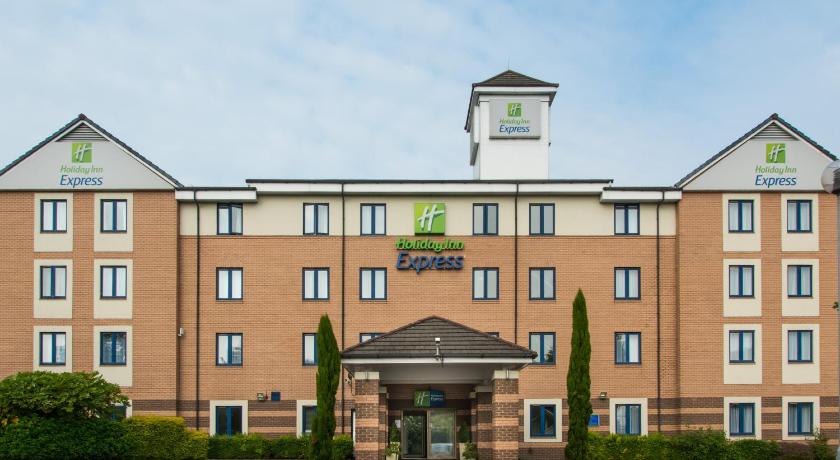 a large brick building with a clock on the front of it, Holiday Inn Express London - Dartford in London