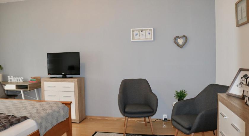 a living room with a couch a chair and a tv, Szabadsag Apartman Pecs in Pecs