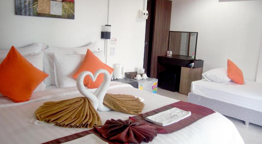 a hotel room with two beds and a table, Chareena Garden Beach Resort in Ko Lipe
